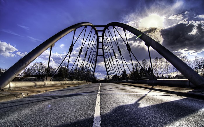 Modern Arch Bridge with Road and Dramatic Sky