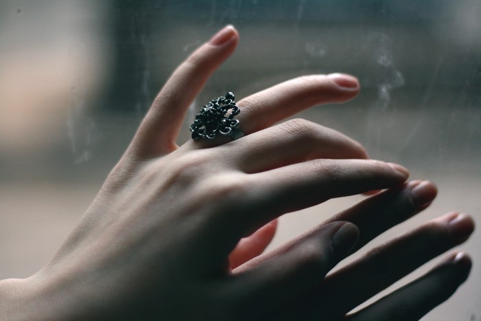 Closeup of a hand wearing a black ornate ring