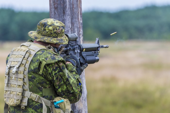 Soldier firing rifle with ejected casing
