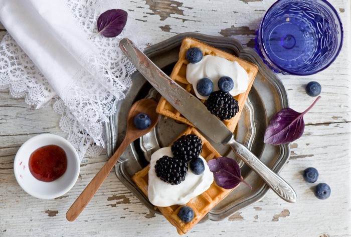 Waffles with whipped cream, berries, and jam
