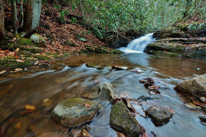 Autumn stream with a small waterfall and rocks