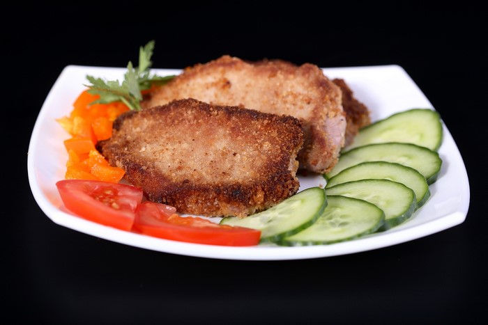 Breaded meat cutlets with cucumber and tomato salad