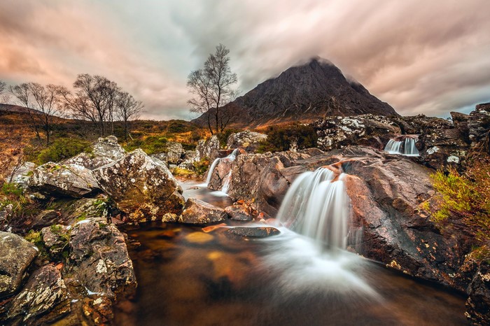 Mountain stream with waterfalls and rocky terrain in Scotland