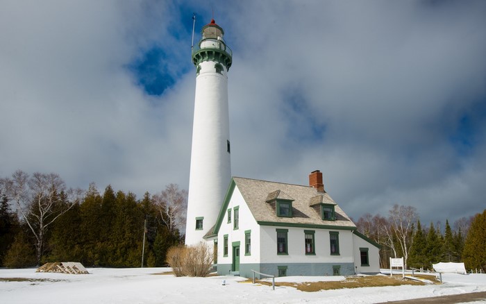 White lighthouse and keeper's house in winter