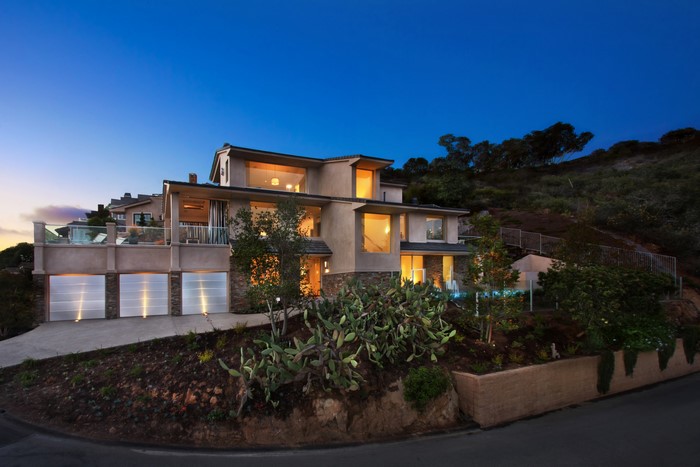 Modern house with garage and balcony at dusk