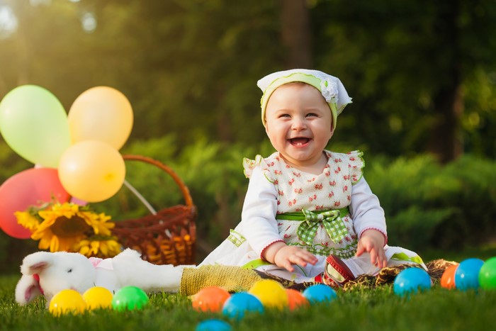 Baby girl with balloons and Easter eggs