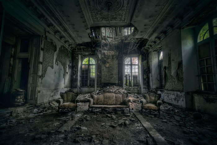 Abandoned room with antique furniture and debris