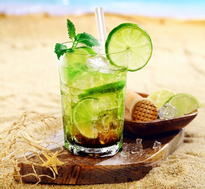 Cocktail with lime and mint on the beach