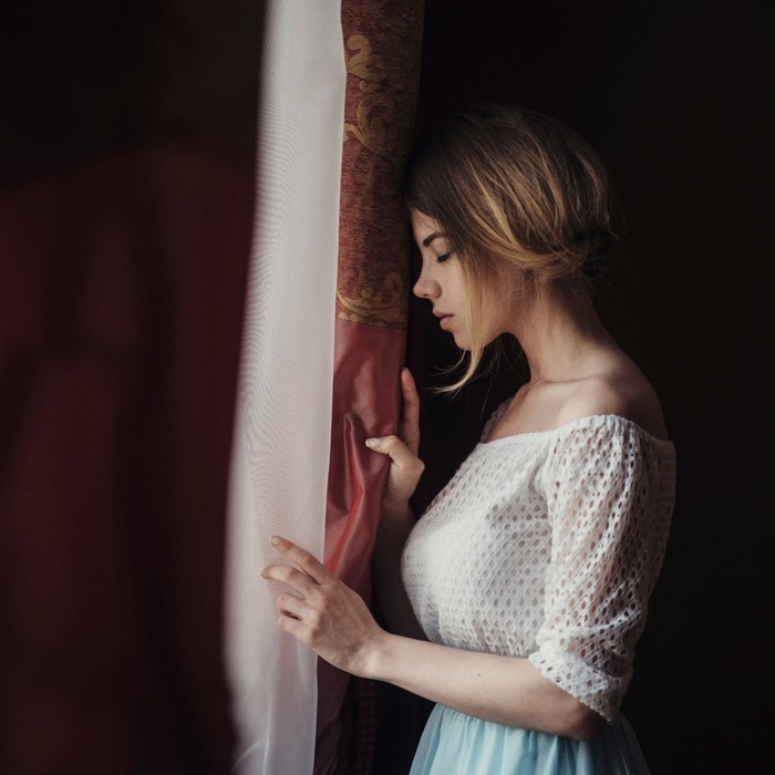 Woman leaning on a curtain