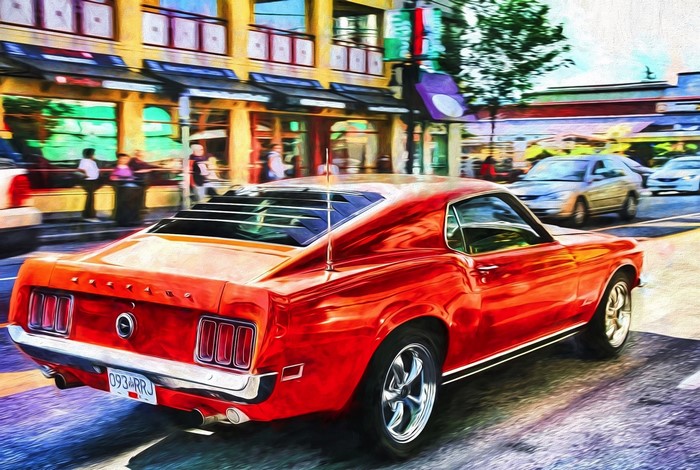 Red 1969 Ford Mustang driving down a street