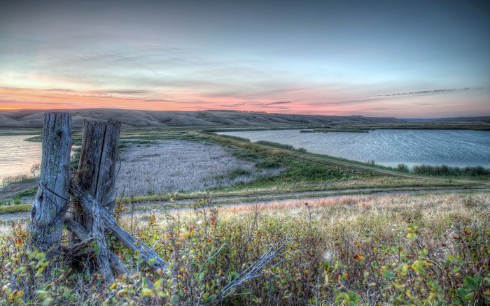 Rural Landscape with Lake and Old Fence at Sunset