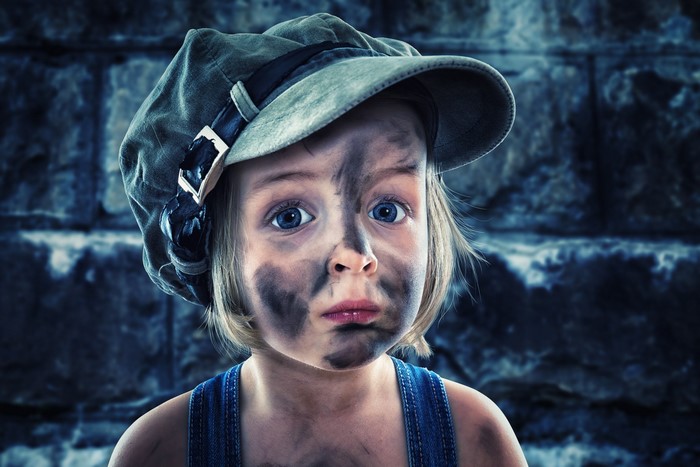 Little girl with dirt on her face wearing a cap