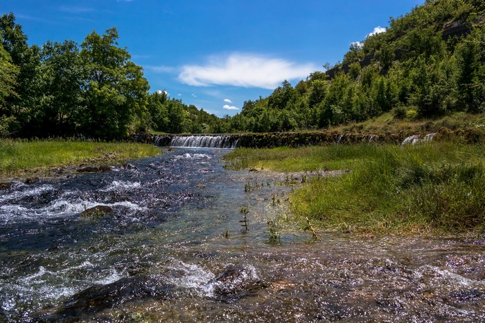 River flowing through a forest with a waterfall in Serbia