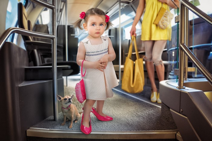 Little girl in dress with dog on a bus