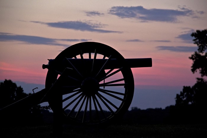 Silhouette of a cannon at sunset