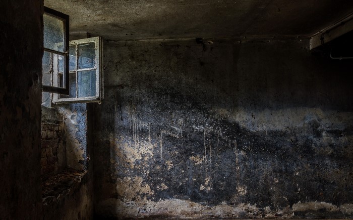 Old room with open windows and damaged walls