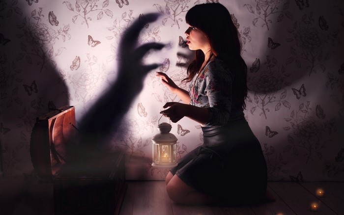 Woman with lantern and shadow hand