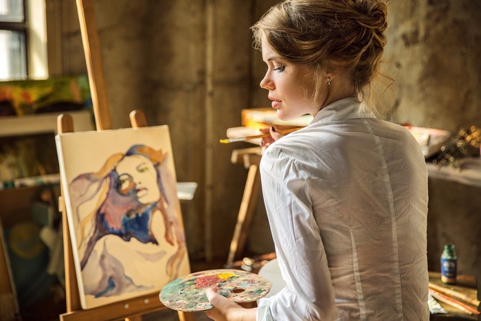 Artist painting a portrait of a woman