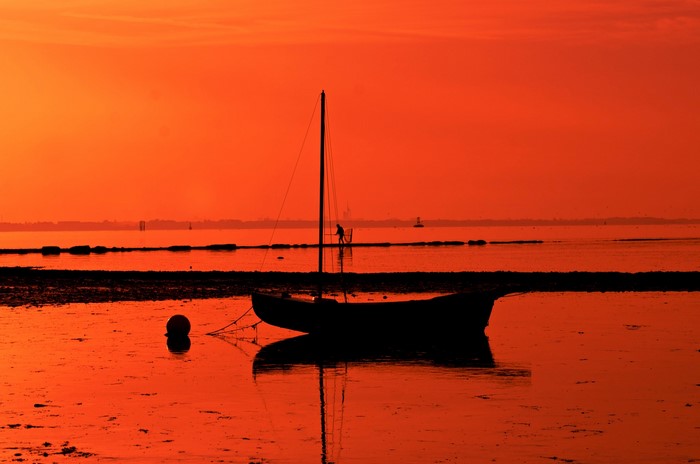 Silhouette of a sailboat at sunset