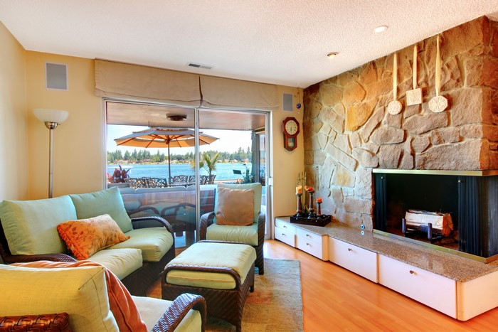 Living room with stone fireplace and water view
