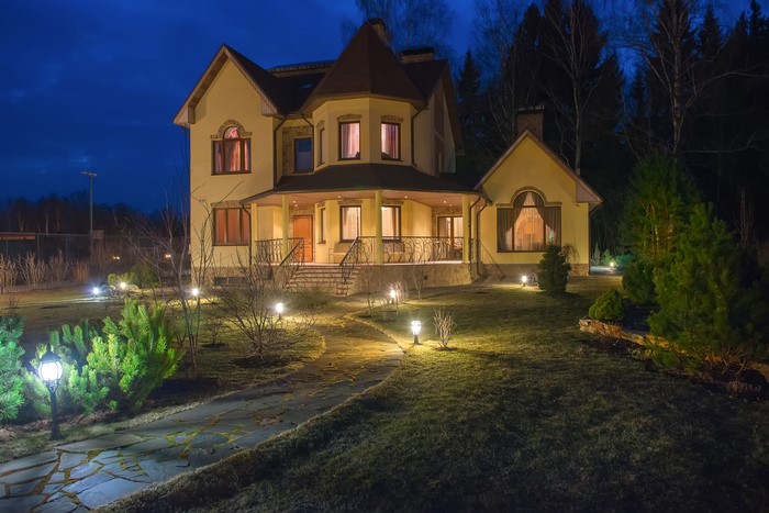 Yellow house at night with garden lights