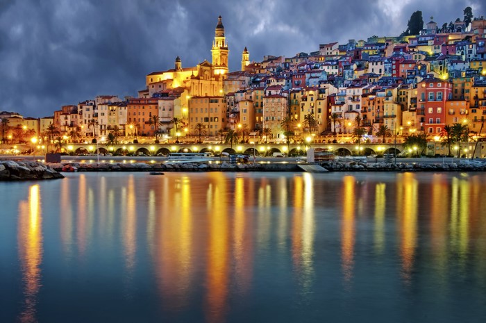 Colorful buildings on a hill overlooking a harbor at night