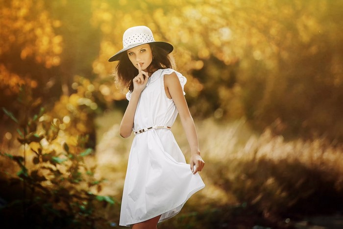 Mary wearing a hat and dress in a forest