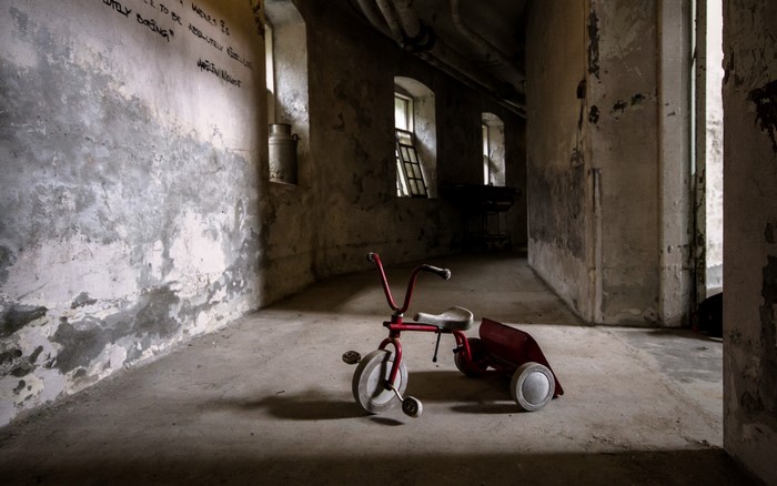 Abandoned hallway with a red tricycle