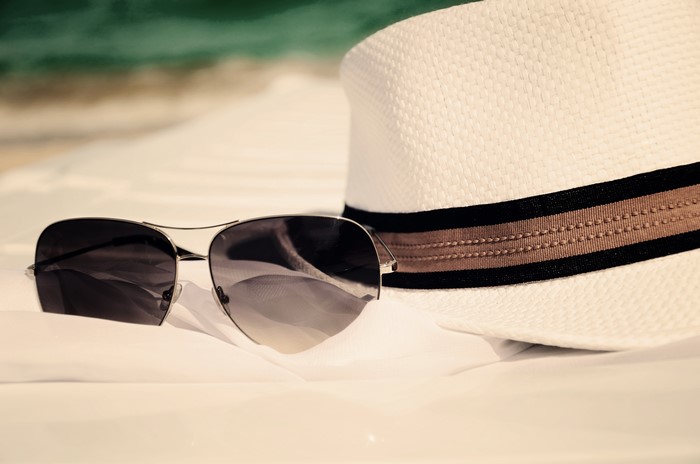 Sunglasses and a hat on the beach