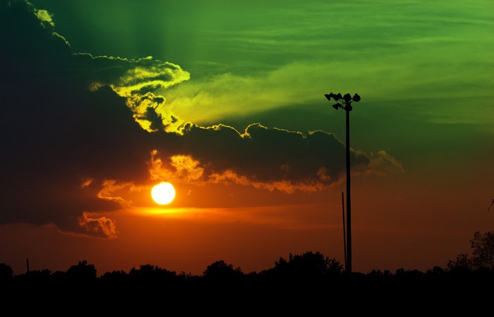 Sunset with clouds and a light pole