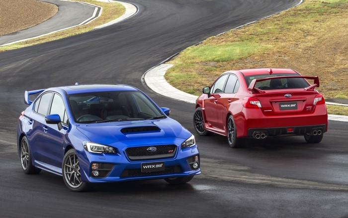 Two Subaru WRX STI cars on a race track