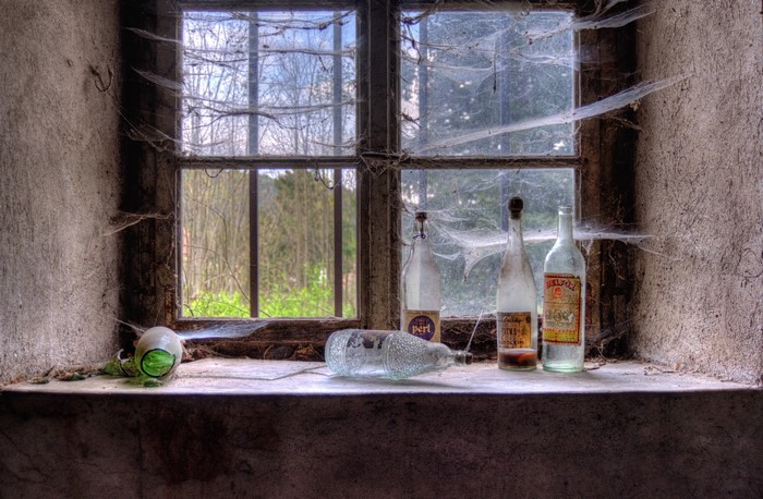 Bottles and spider webs on a windowsill