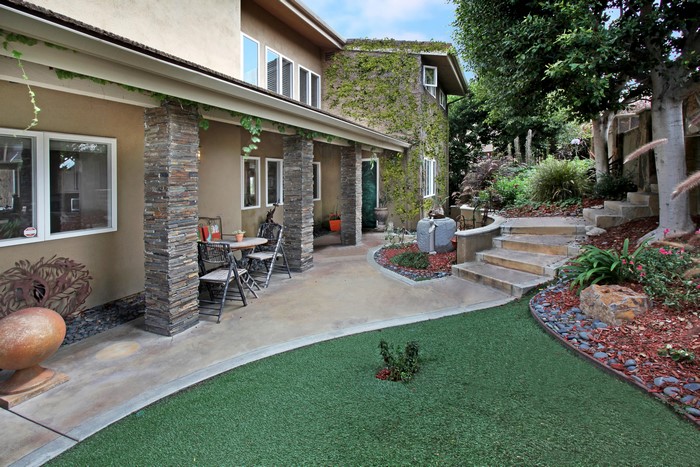 House with stone pillars and a tiered garden