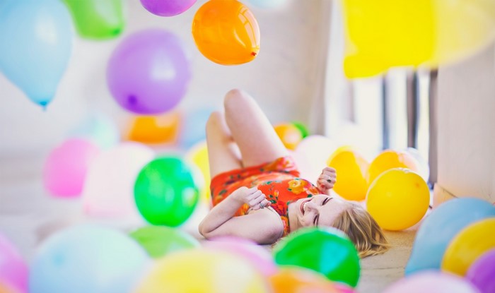 Blonde girl lying among balloons