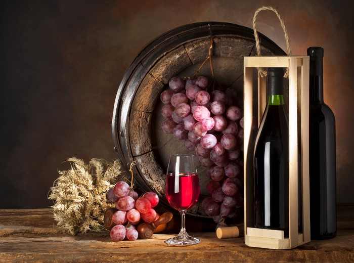 Wine barrel with grapes, wine bottle, and glass