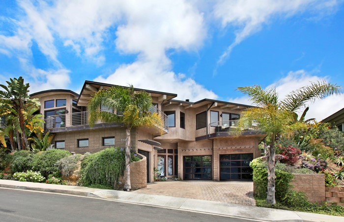 Modern mansion with palm trees and shrubs