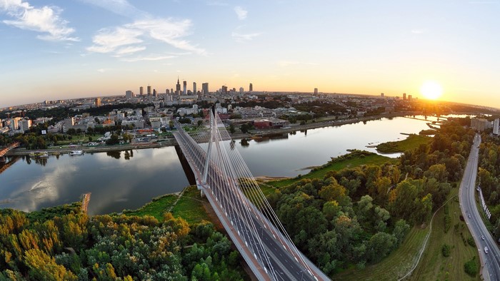Warsaw cityscape with Vistula River and bridge at sunset