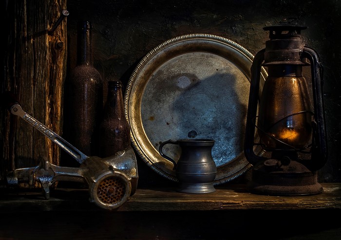 Still life with meat grinder, bottles, tray, and lantern
