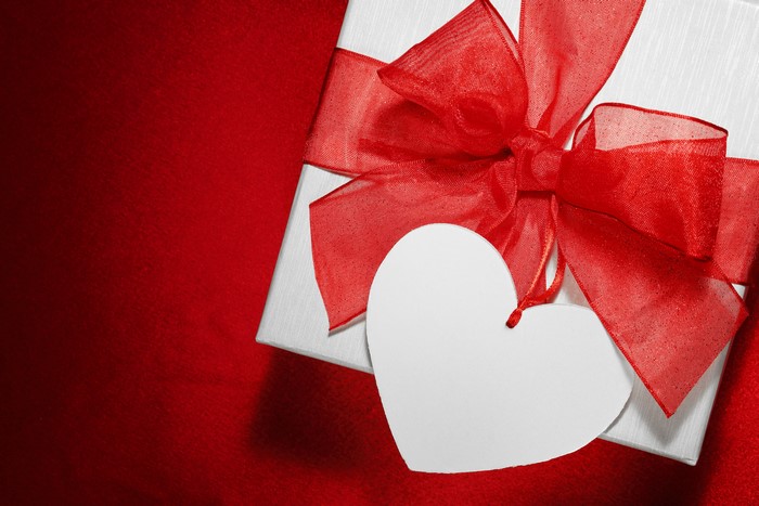 White gift box with red ribbon and heart tag