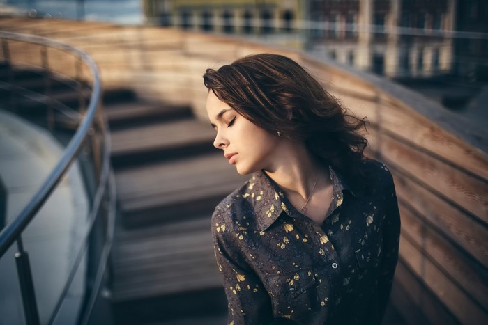 Woman with eyes closed on wooden stairs