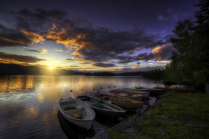 Boats on a lake at sunset with dramatic clouds