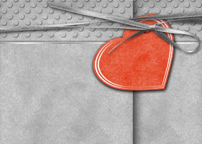 Red heart gift tag with ribbon on grey background