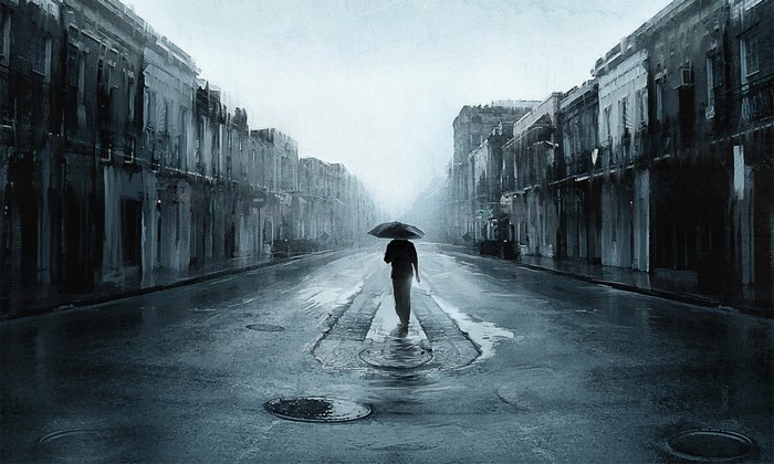 Person with umbrella walking down a rainy street