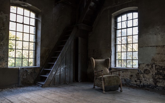 Abandoned room with armchair and staircase