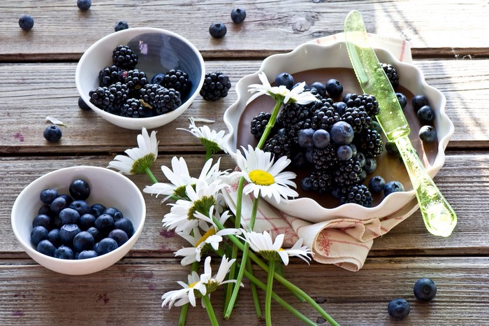 Blackberries and blueberries with daisies