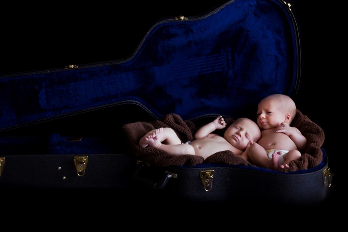 Two infants in a guitar case