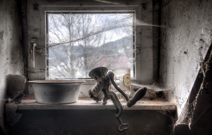 Old meat grinder and basin on a windowsill