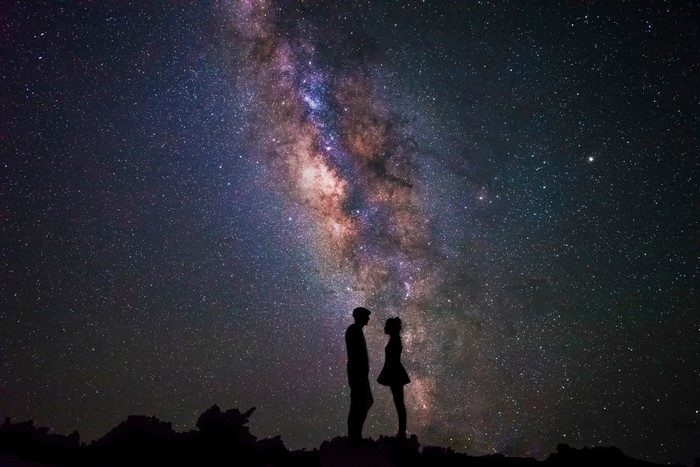 Couple silhouetted against the Milky Way