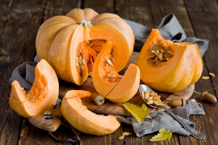 Whole and sliced pumpkins with seeds
