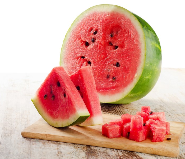 Watermelon slices and cubes on a wooden board